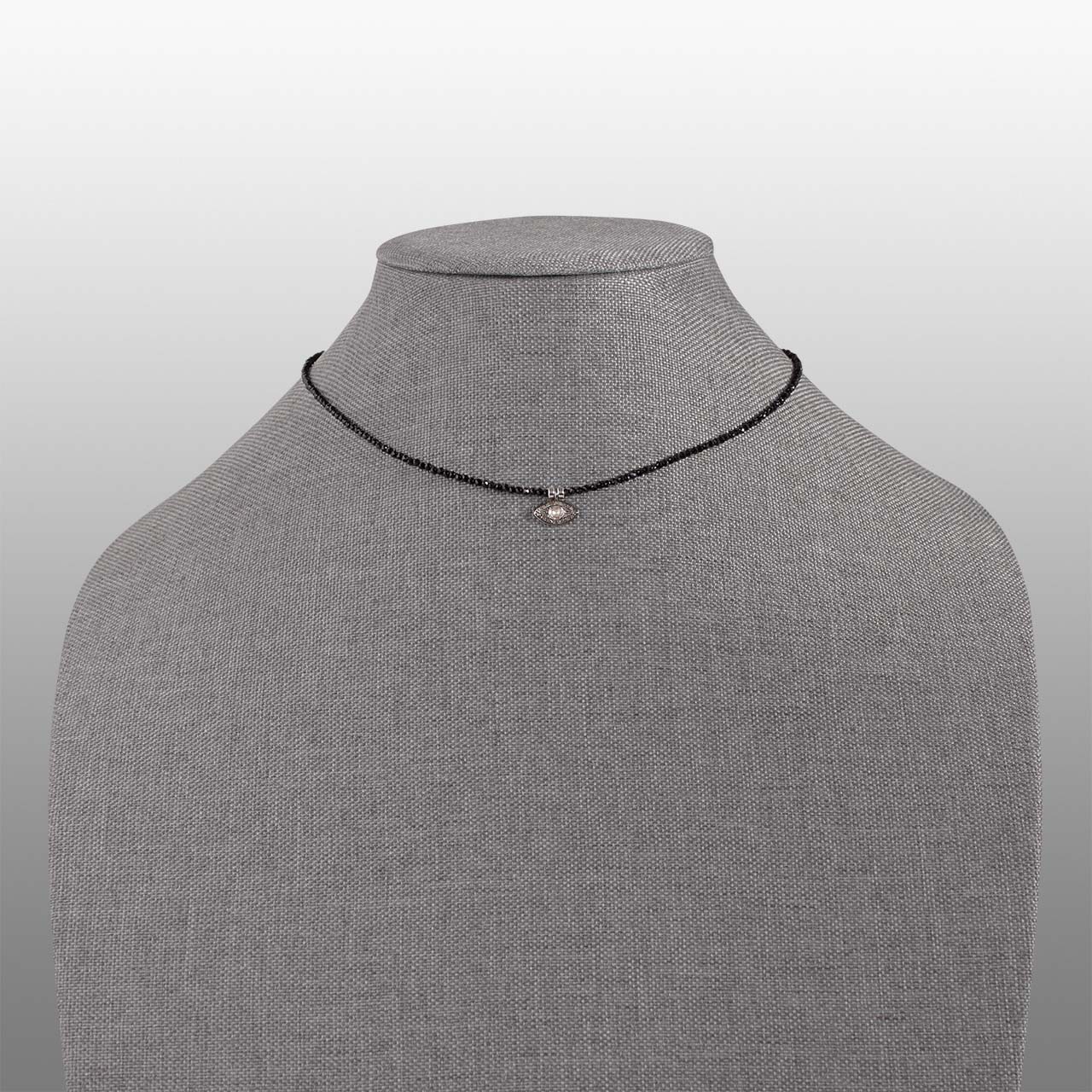black spinel faceted bead with polki diamond evil eye charm necklace front on grey textured necklace form