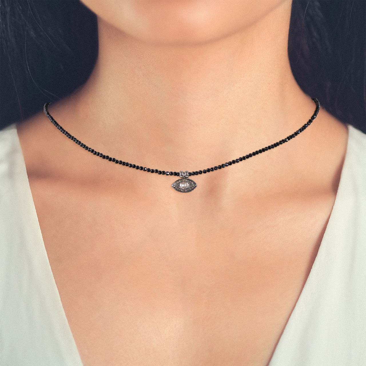 black spinel faceted bead with polki diamond evil eye charm necklace front on model neckline