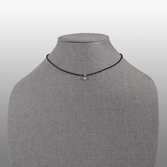 black spinel faceted bead with polki diamond evil eye charm necklace front on grey textured necklace form