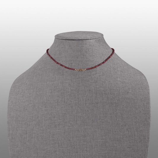 garnet faceted bead with gold filled magnetic clasp necklace back on grey textured necklace form