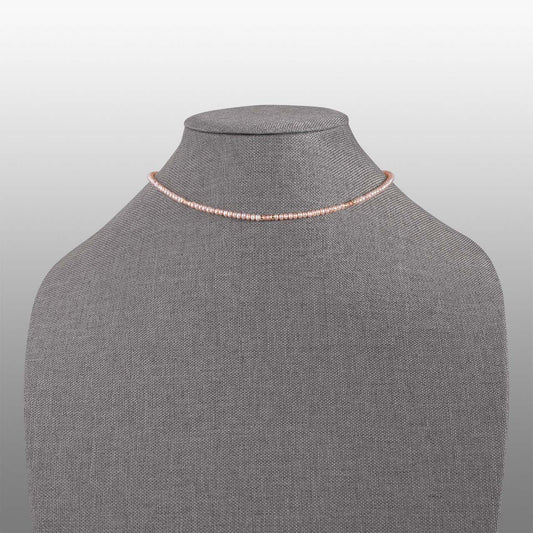 peach button pearl and pink faceted zircon beads with gold filled accents necklace front on grey textured necklace form