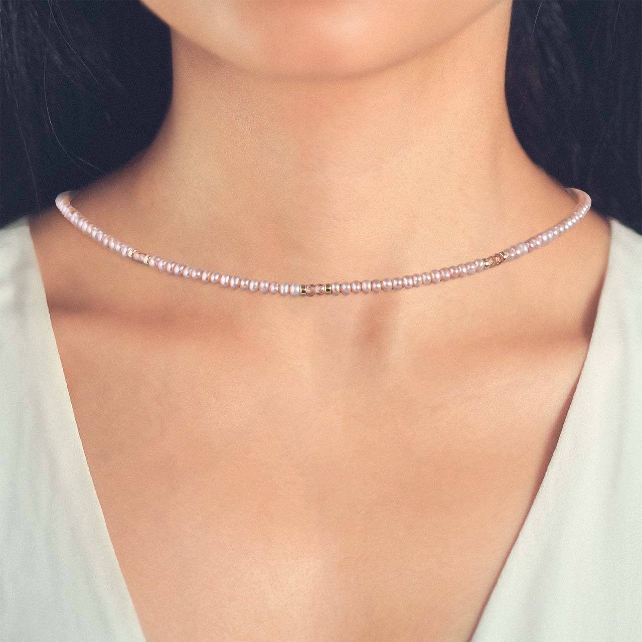 peach button pearl and peach zircon faceted bead with gold filled accents necklace front on a model neckline
