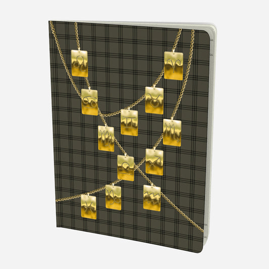 front cover of large notebook with gold zodiac tags on chains on and olive and black plaid background